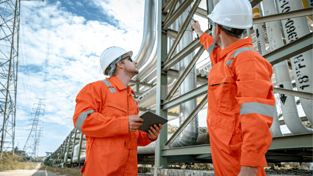 two engineers pointing at an oil rig